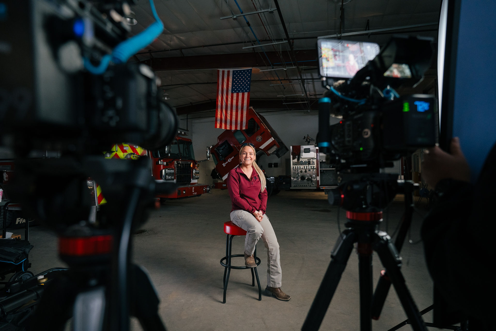 A documentary interview set inside an apparatus bay beneath an American flag