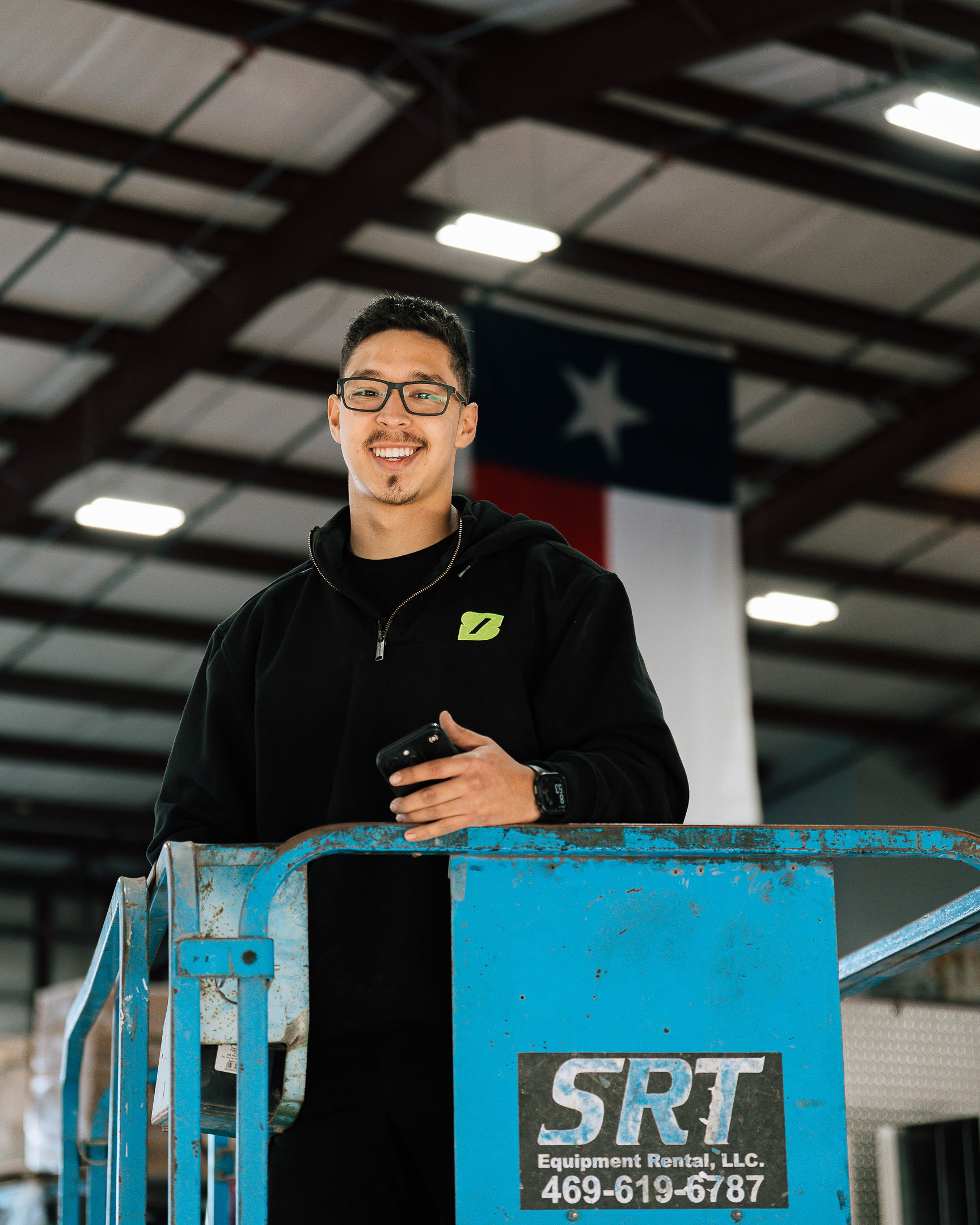 A Texas teammate on a lift beneath the state flag